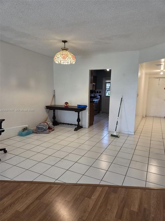 Ceramic tile flooring, drop-in decorative pendant lighting, and wood-finish flooring