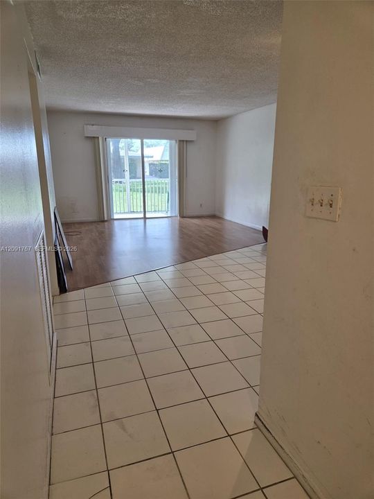 Interior space featuring ceramic tile flooring, wood-finish flooring, and sliding glass doors