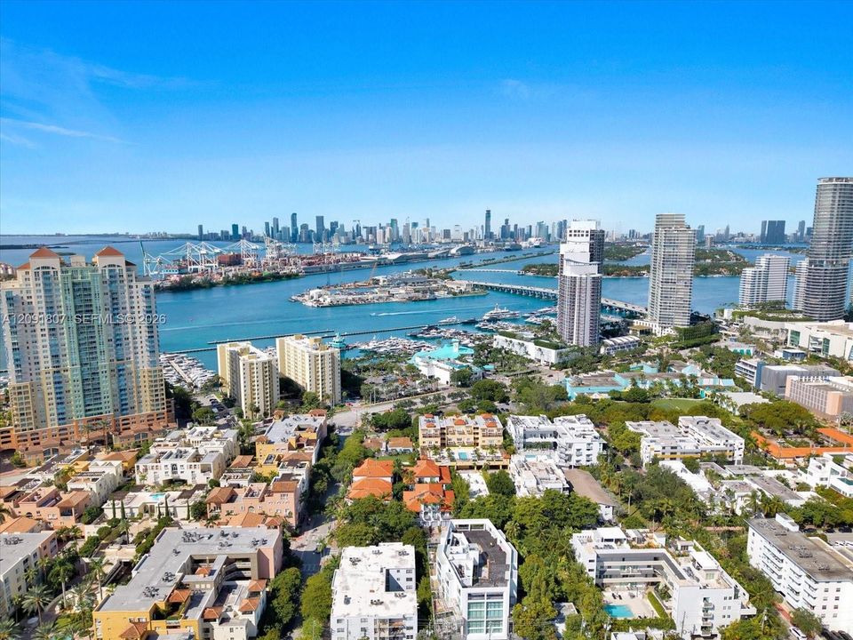 Aerial perspective featuring an urban skyline, harbor with deep-water access, multi-level residential structures, and coastal waterfront access