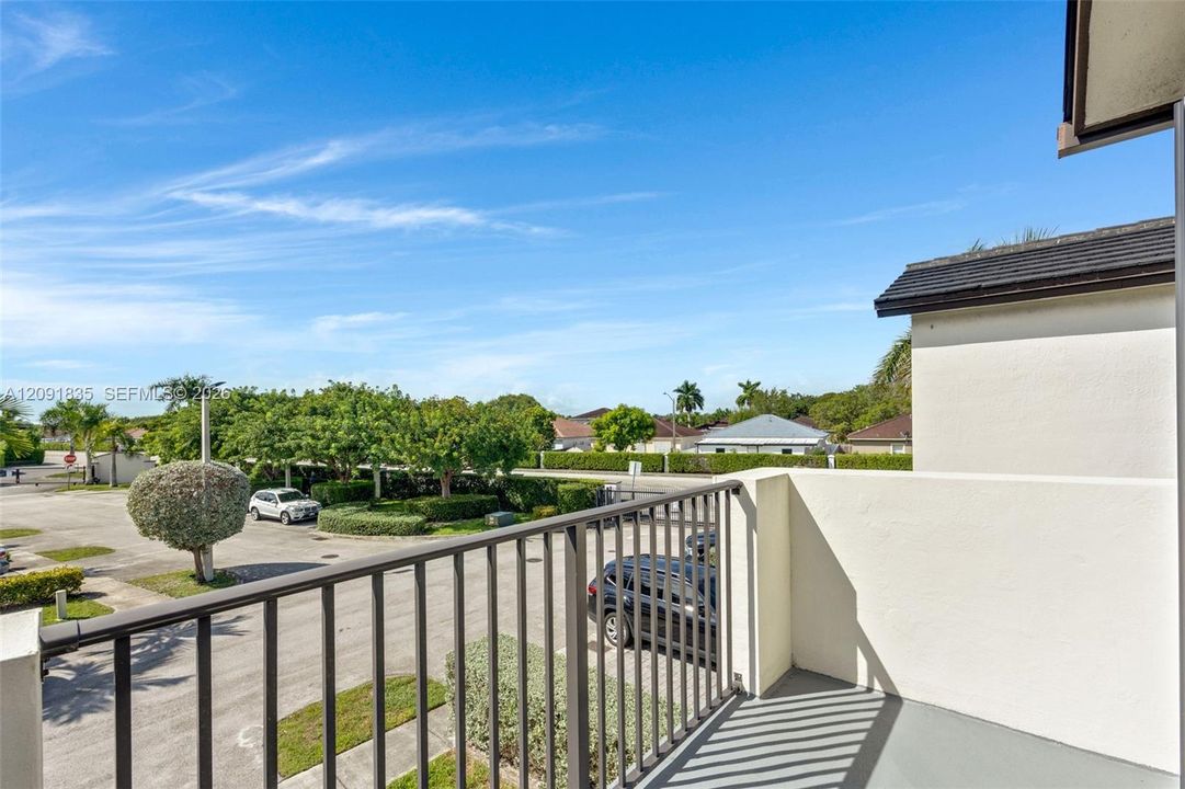 Elevated outdoorvered balcony with smooth-finish concrete balcony featuring solid wall privacy screening and a metal railing