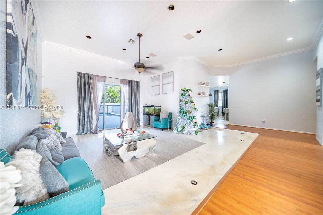 High ceilings featuring recessed lighting, custom-finished concrete flooring, integrated ceiling fan, and sliding glass doors leading to an outdoor space