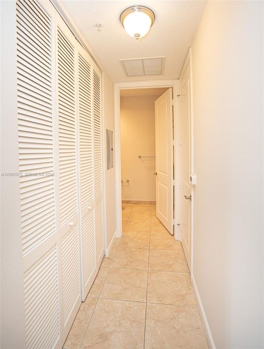 Recessed ceiling light fixture, louvered bi-fold closet doors, tile flooring, and white interior doors