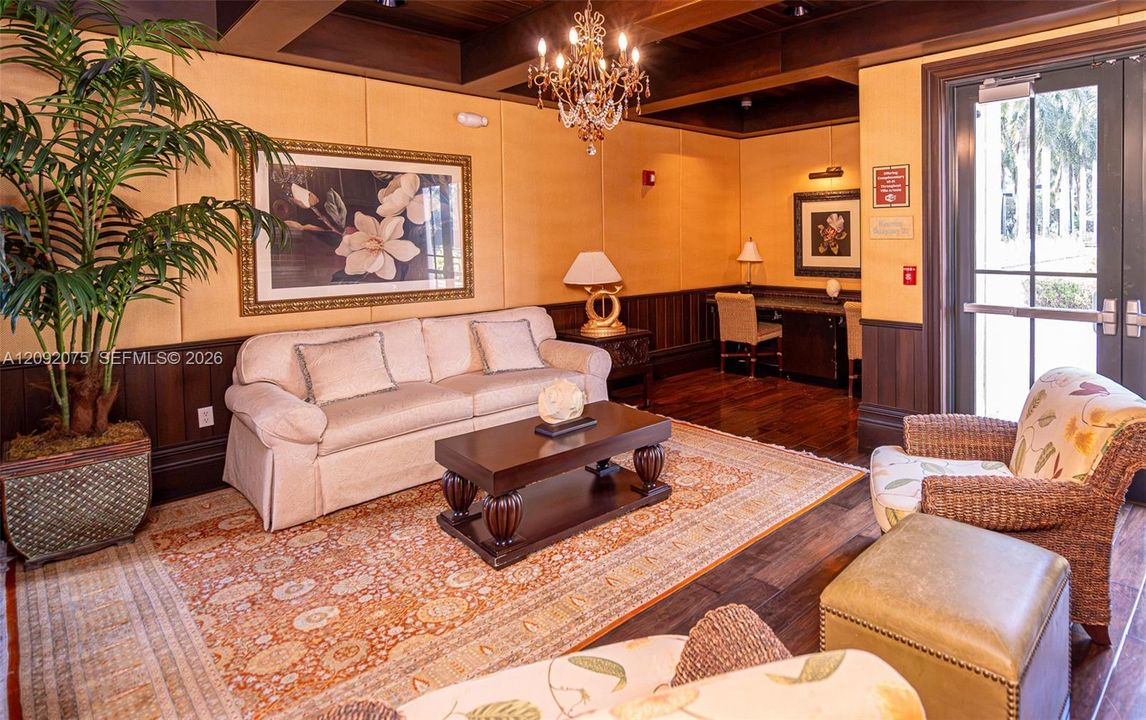 Wood-finish flooring, dark wood wainscoting, and a chandelier with decorative accents