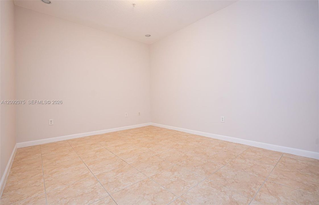 Recessed lighting, neutral wall tones, and tiled flooring
