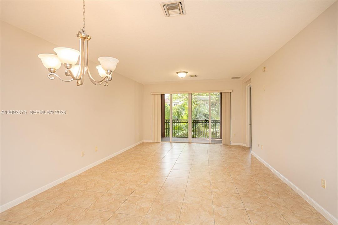 Neutral-toned walls and tile flooring create an expansive open-concept living area
