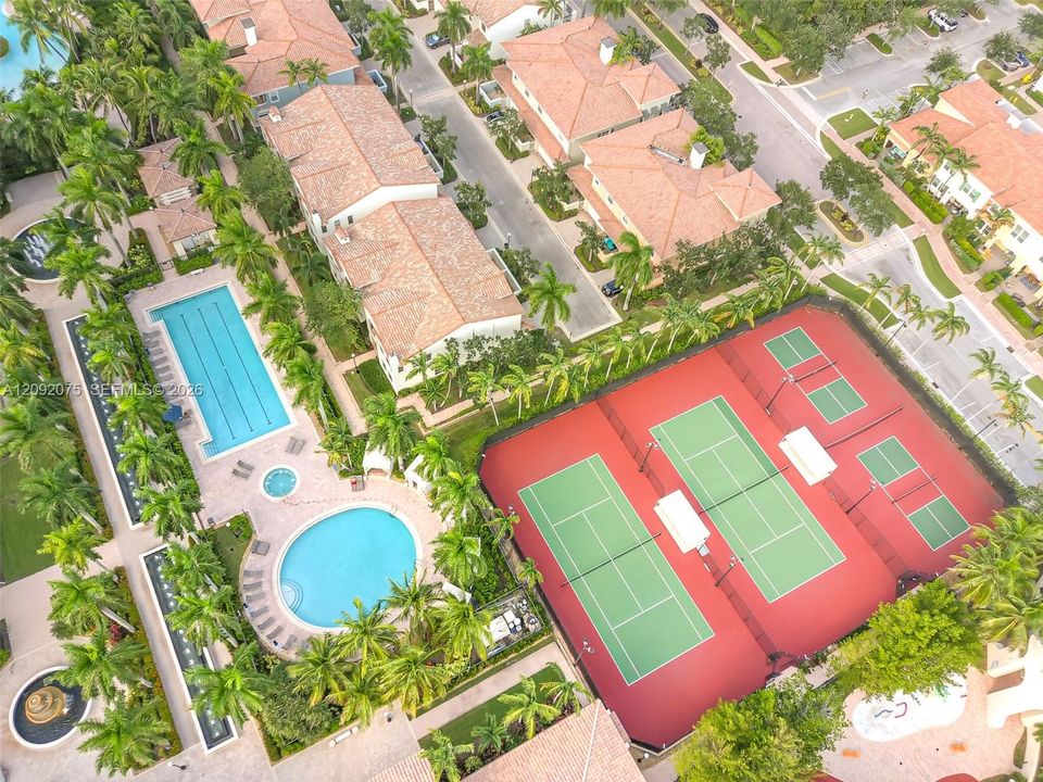 Outdoor amenities featuring multiple swimming pools, a spa, and tennis courts set among lush landscaping
