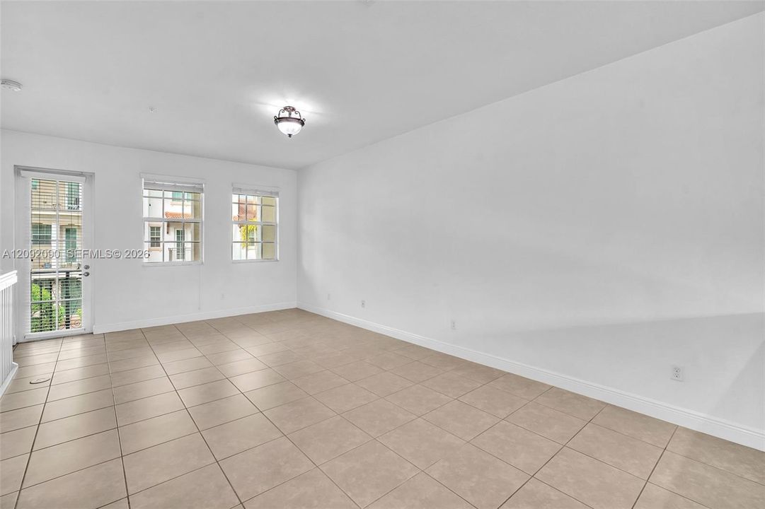 Neutral-toned tile flooring, multi-pane windows, a glass-paneled door, and a ceiling-mounted light fixture
