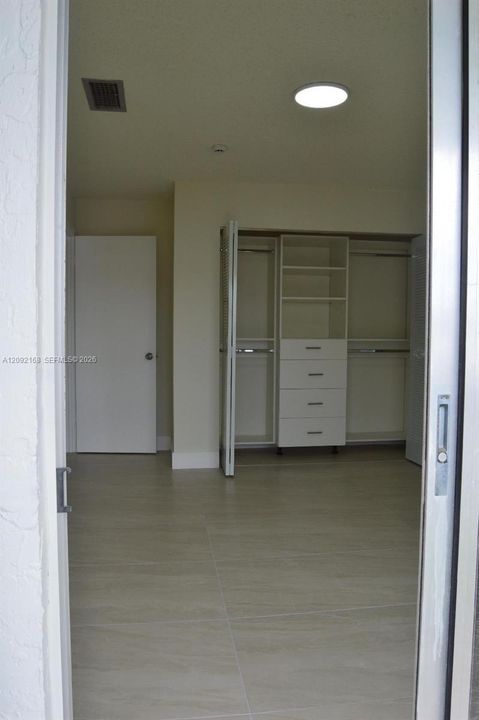VIEW OF THE 2ND BEDROOM WITH BALCONY'S BRAND NEW CLOSETS