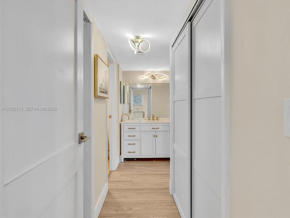 Hallway leading to the primary suite with custom built-in closets and private bathroom