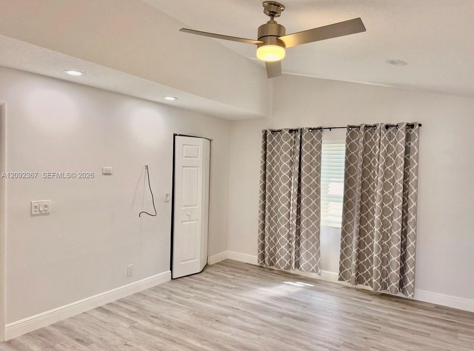 Primary Bedroom on first floor with drapes and walk in closet.
