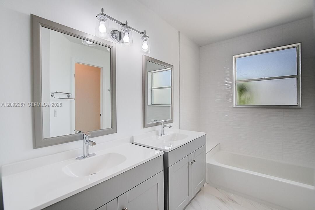 Primary Bathroom with double vanities and shower/tub combination.