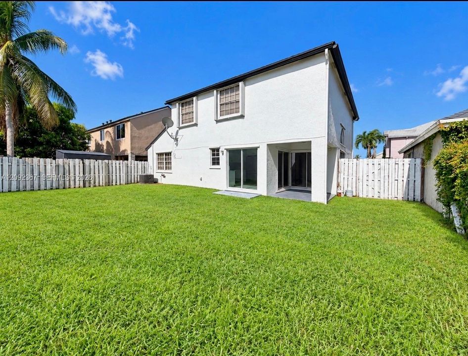 View of 3 sliding glass doors that lead to private large fenced back yard.
