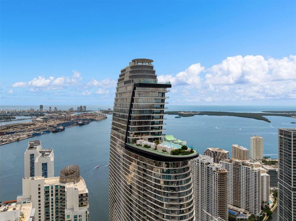 High-rise architectural structure featuring a prominent cantilevered deck, perimeter glass railing, swimming pool, and tiered balcony levels