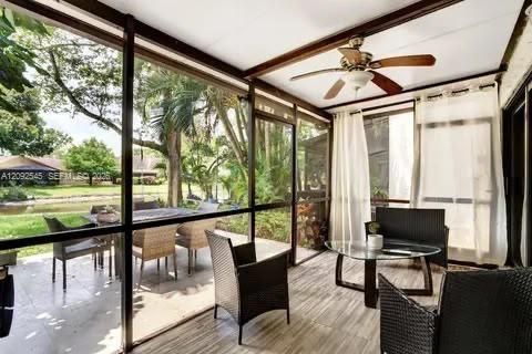 Screened-in Lanai: Covered screened-in patio featuring ceiling fan and sliding glass doors, expanding your indoor-outdoor living space year-round.