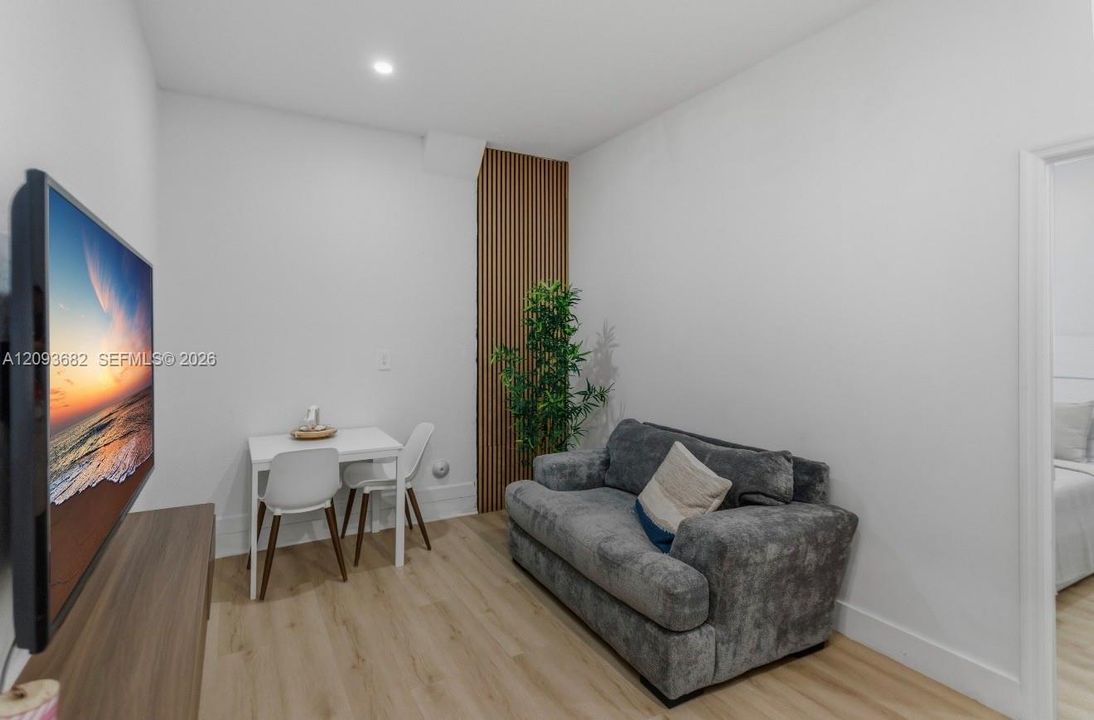 Interior space featuring wood-finish flooring, vertical slat wood wall paneling, and a recessed ceiling light fixture