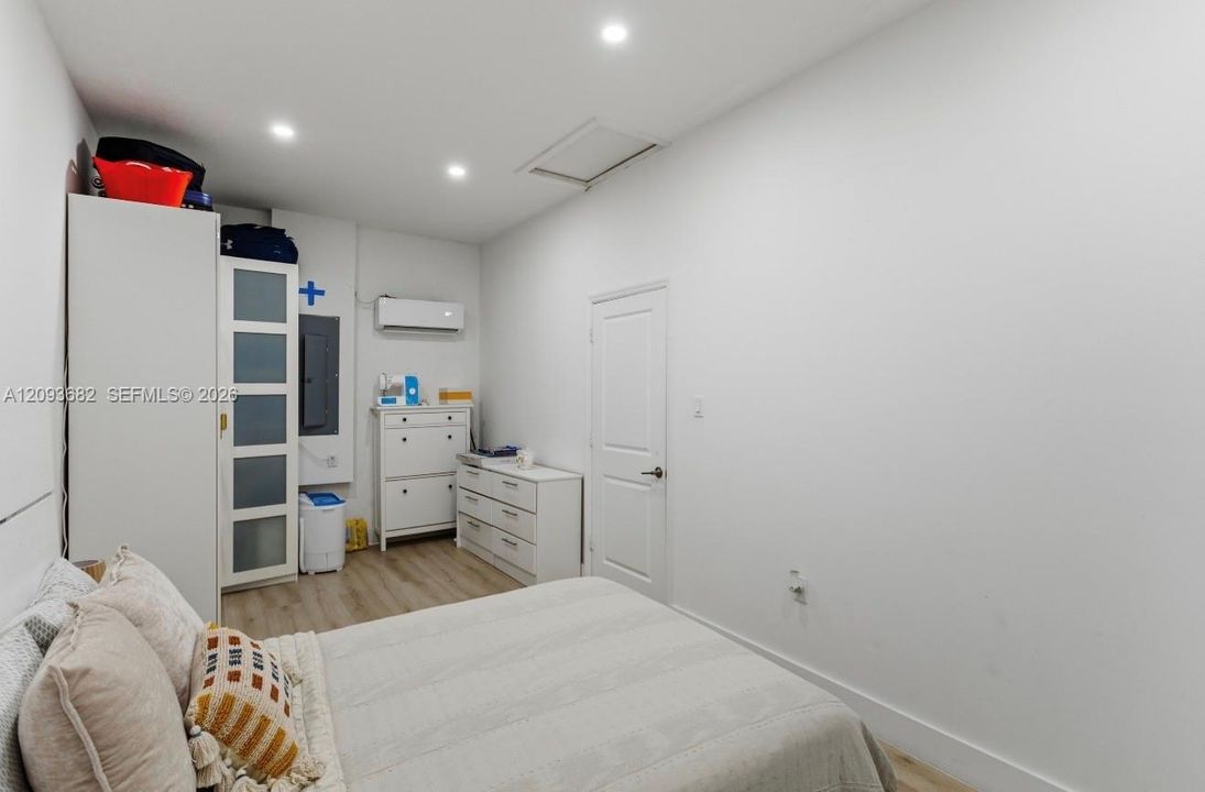Room featuring wood-finish flooring, recessed lighting, and a wall-mounted ductless climate control unit
