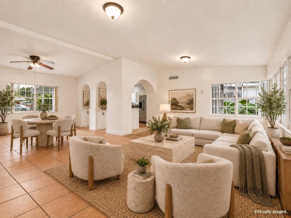 Virtually staged: great room with living and dining areas and arches to the kitchen