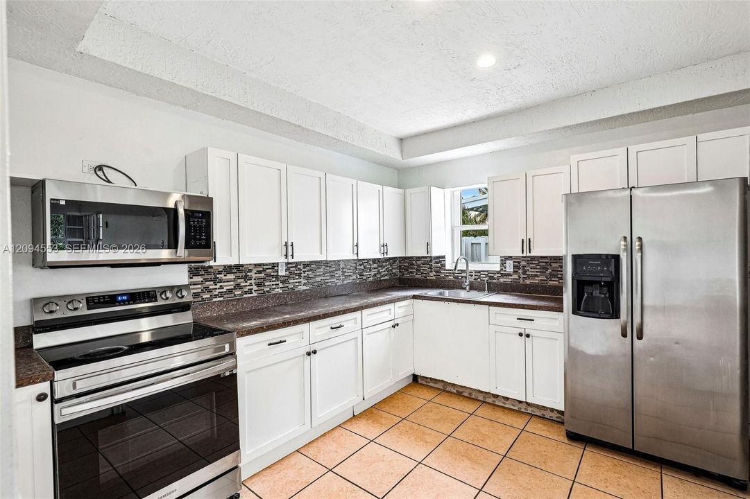 Kitchen with white shaker cabinets and stainless steel appliances