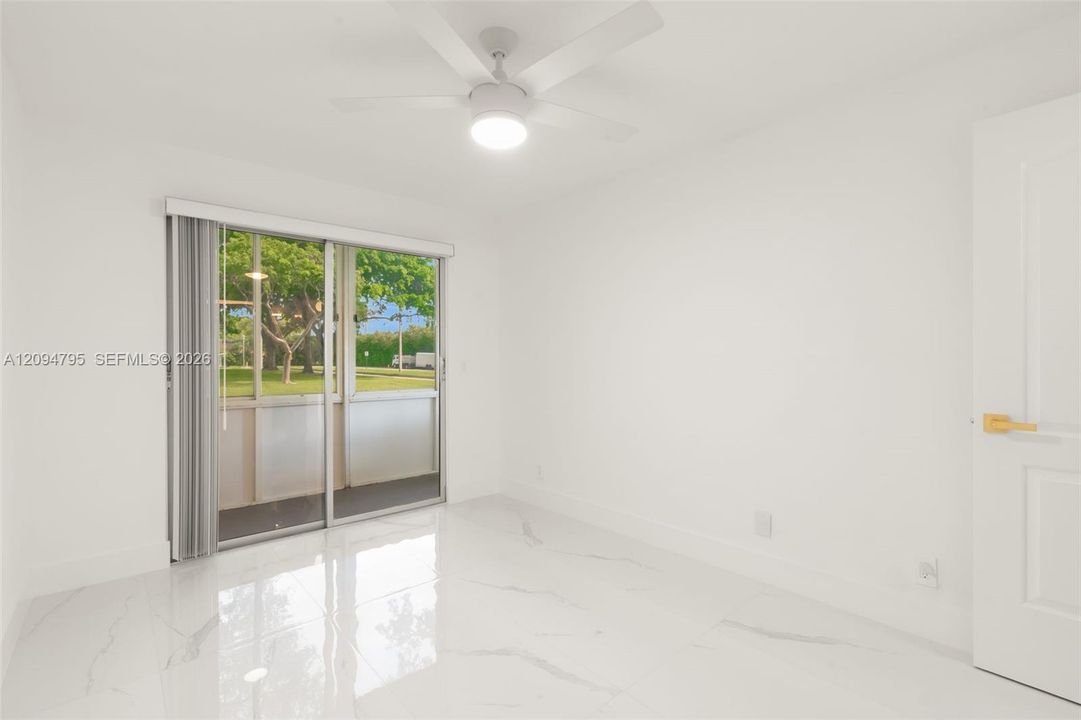 Secondary Bedroom with access to enclosed patio with storage.