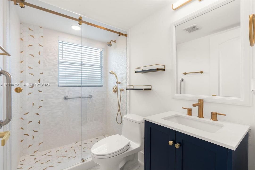 Primary bathroom with gold accents.