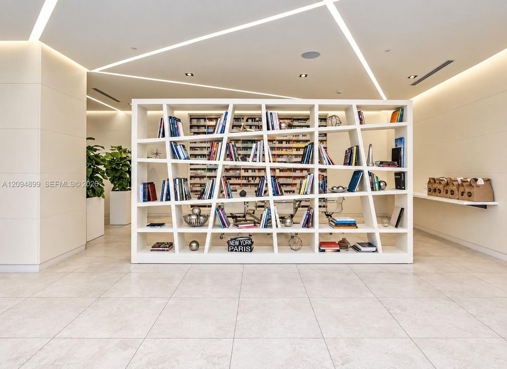 Built-in geometric shelving unit featuring white framing, large-format tile flooring, linear recessed ceiling lighting, and smooth panel walls