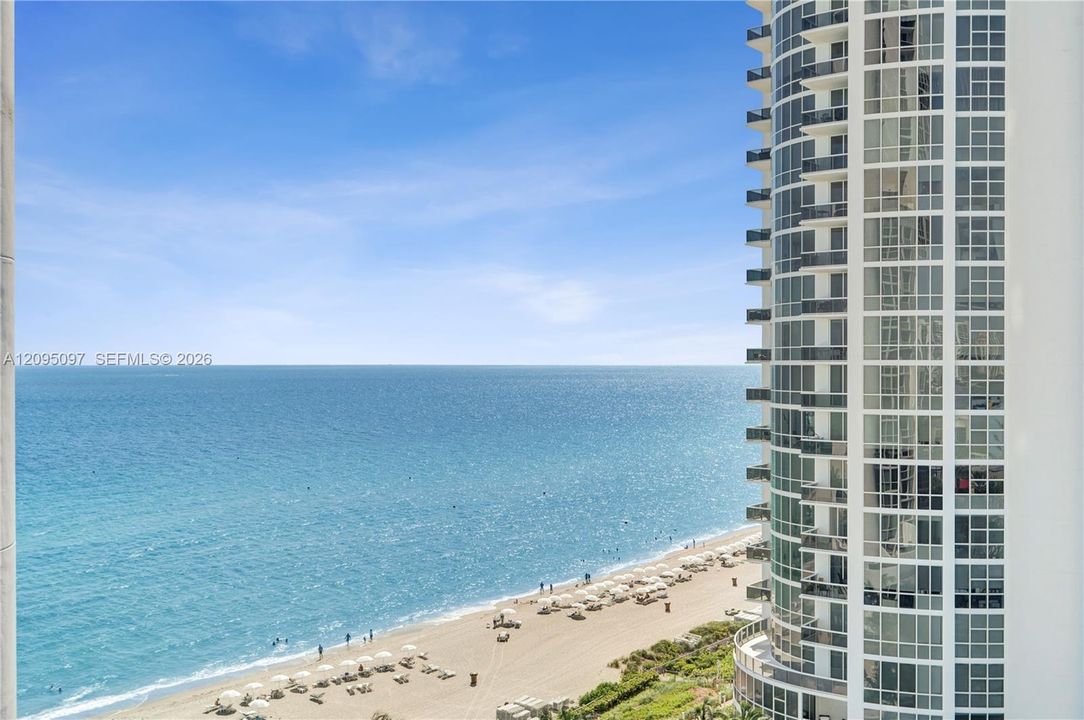 High-rise structure featuring floor-to-ceiling glass windows and private balconies overlooking the oceanfront