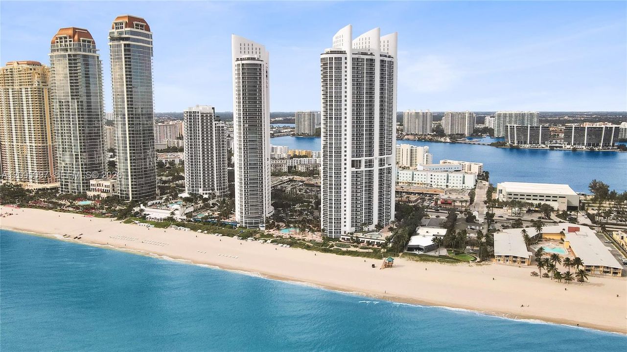 High-rise coastal towers featuring direct oceanfront access, private sandy beach frontage, and panoramic water horizons