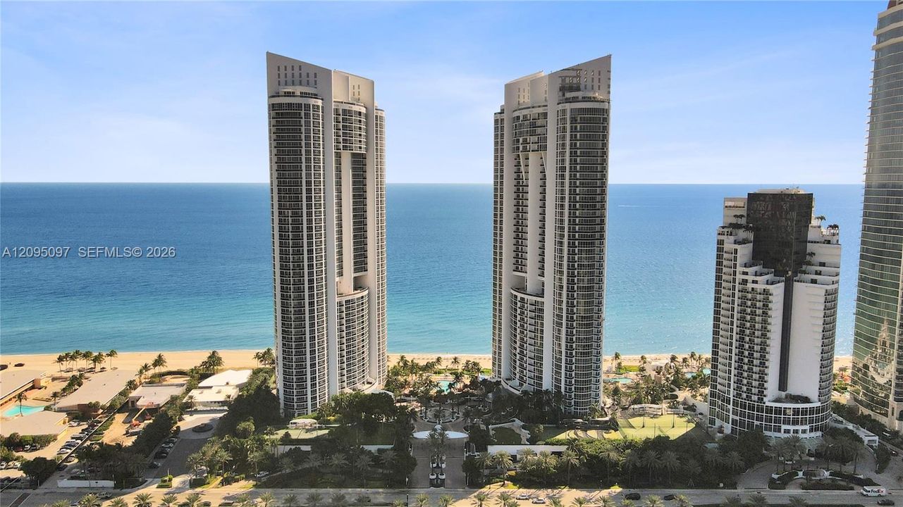 High-rise coastal towers featuring glass-paneled balconies and direct oceanfront positioning