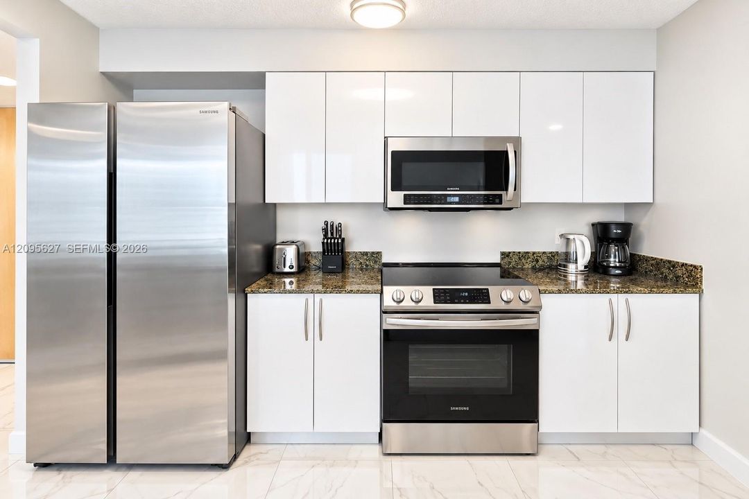 Modern white kitchen with stainless steel appliances