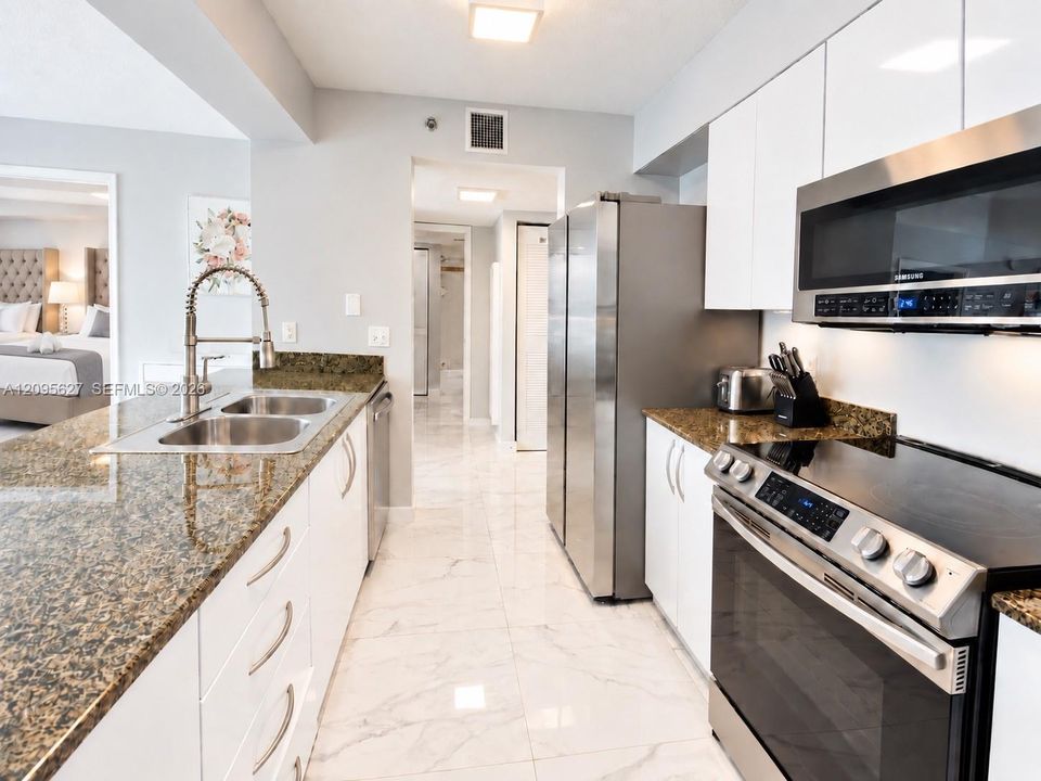 White modern kitchen with granite counters and stainless steel appliances