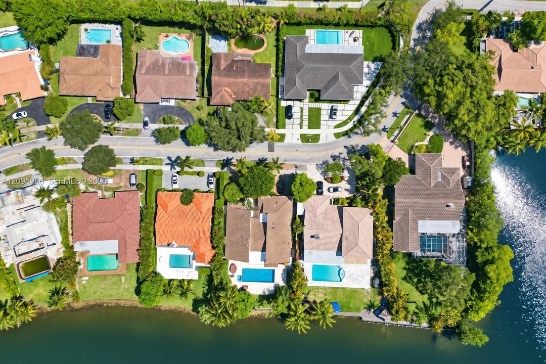 Waterfront community featuring multiple residences with private pool amenities, mature landscaping, and direct water access