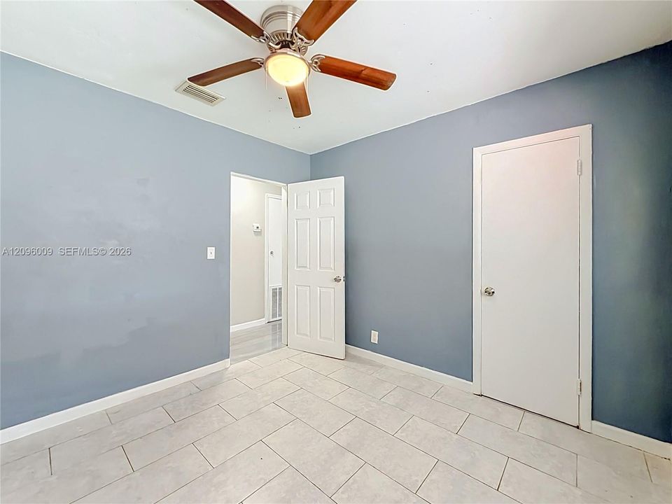 Interior space featuring ceramic tile flooring, a multi-blade ceiling fan with integrated lighting, and six-panel interior doors