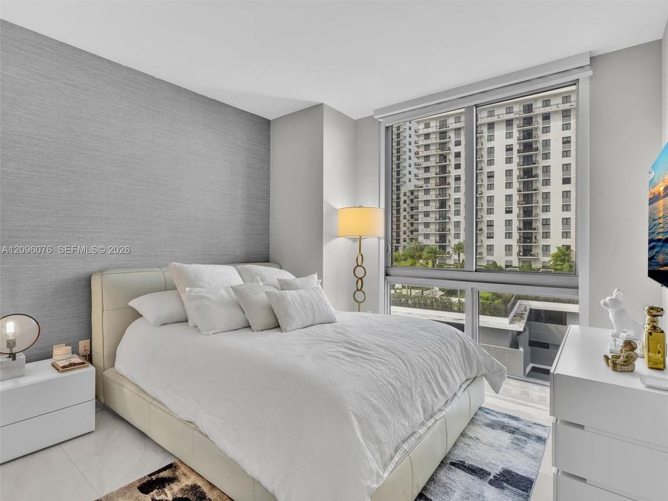 Textured gray accent wall, floor-to-ceiling windows, and polished tile flooring