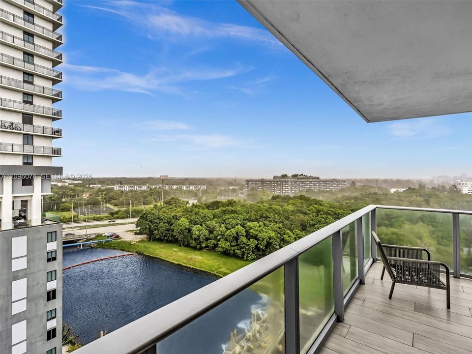 Private balcony featuring wood-finish tile flooring and a glass railing
