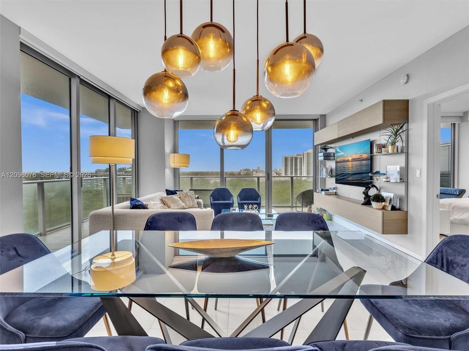 Multi-light pendant fixture with metallic-finish glass globes, floor-to-ceiling glass panel walls, and built-in wall-mounted cabinetry with a neutral wood-finish