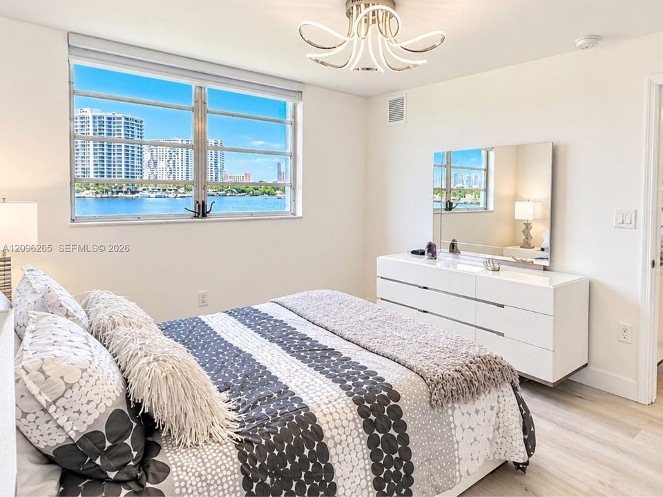 Alternate view of the primary bedroom showcasing full furnishings and clean modern finishes.