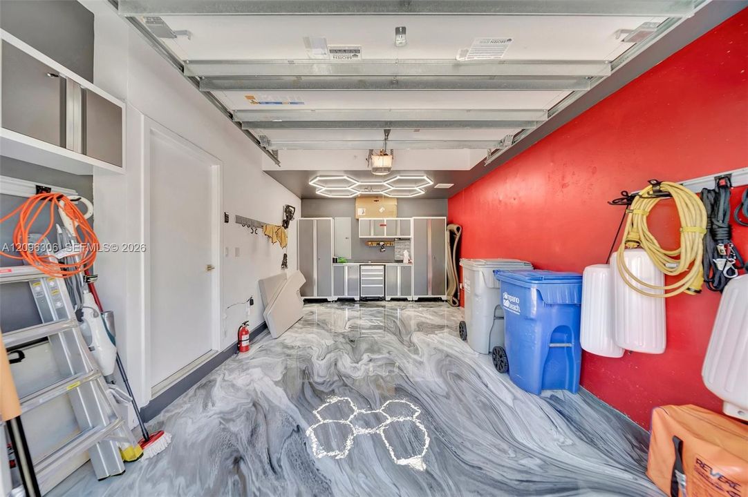Garage with custom epoxy flooring and lighting - door to left leads into the foyer
