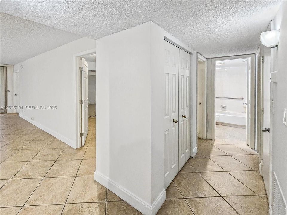 Neutral-toned ceramic tile flooring, built-in double-door closet, and six-panel interior doors