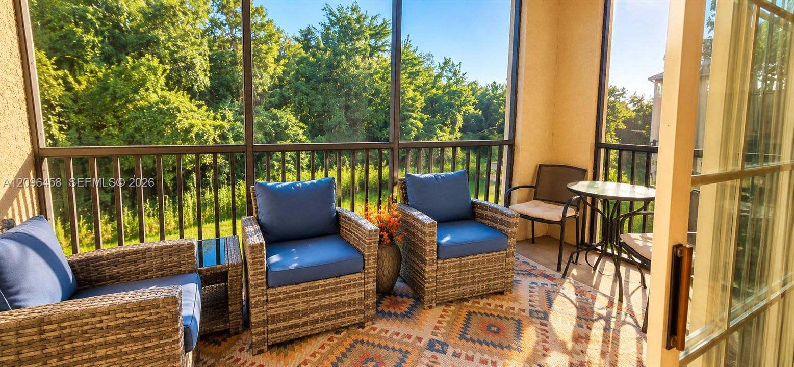 Screened-in porch featuring metal railing, tiled flooring, and sliding glass entry door