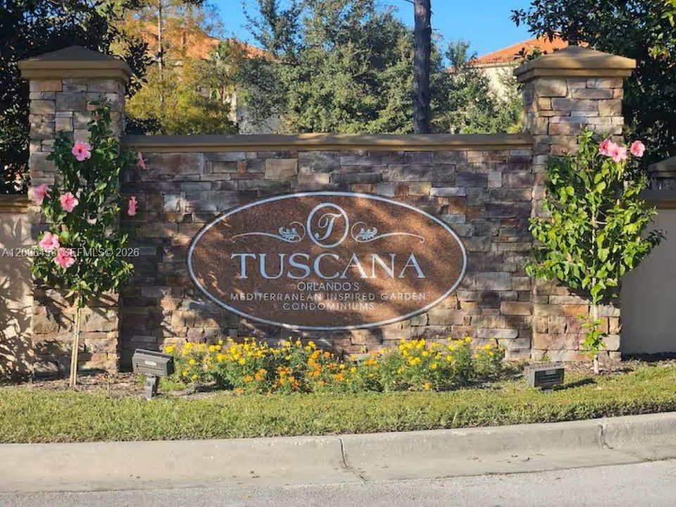 Custom stone monument sign featuring dual pillar accents, inlaid metal signage, and integrated landscaping with flowering shrubs