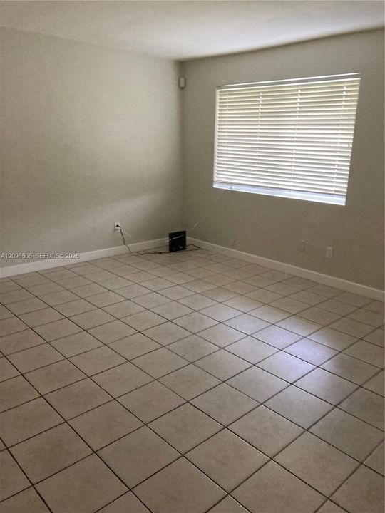 Neutral wall color, ceramic tile flooring, and a window with horizontal blinds