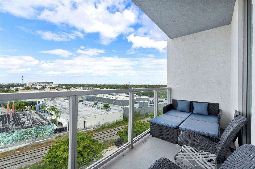 Private balcony featuring a glass-panel railing and concrete flooring