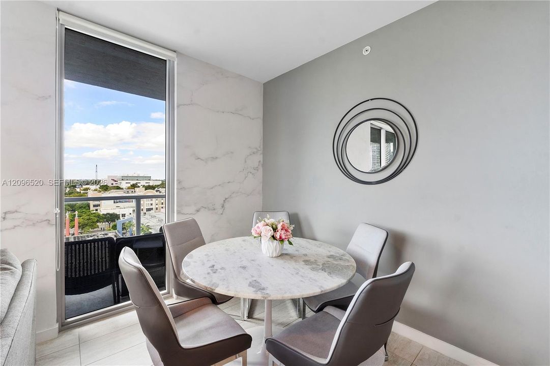 Floor-to-ceiling glass door with integrated balcony, stone-finish wall cladding, and large-format tile flooring