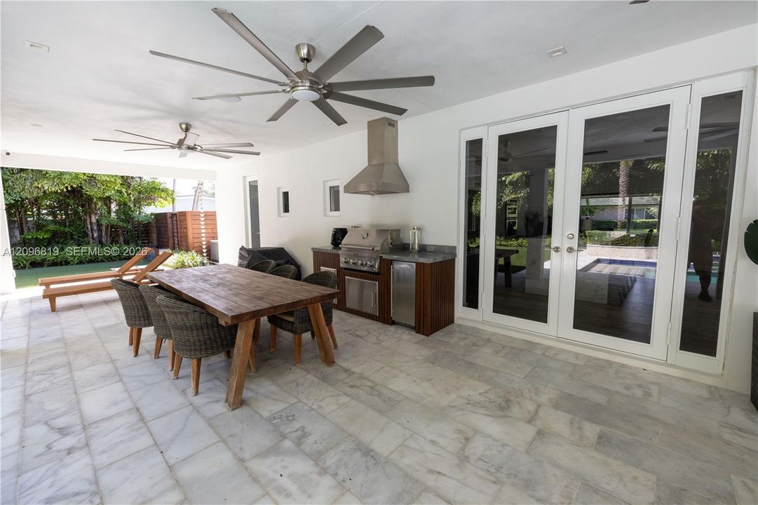 Spacious covered outdoor living area with built-in BBQ Kitchen, dining area, and plenty of space for entertaining.