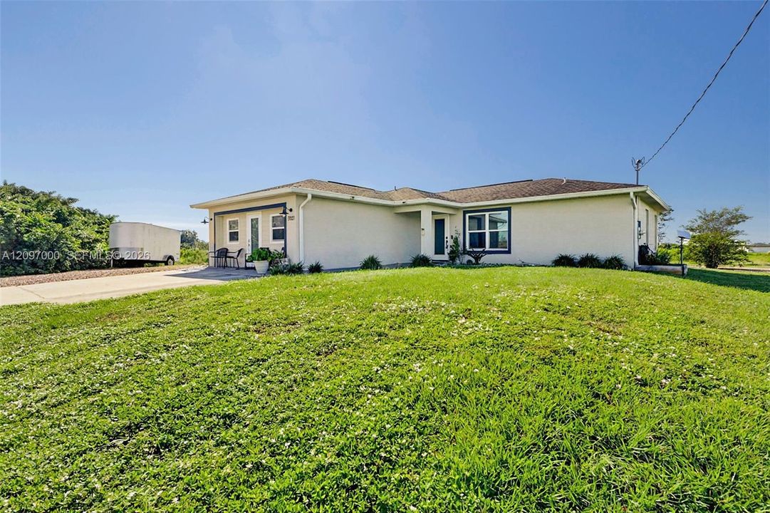 Single-story ranch-style exterior featuring a stucco facade, hipped roofline, concrete driveway, and covered entryway