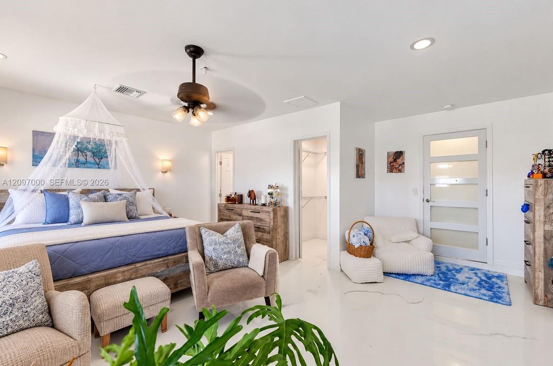 Spacious room featuring glossy tile flooring, recessed lighting, a modern ceiling fan with integrated light fixtures, wall-mounted accent lighting, and a contemporary entry door with frosted glass panels