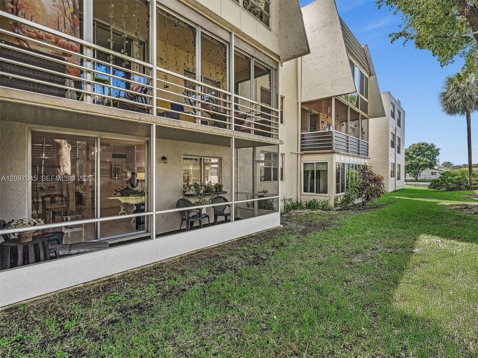 Multi-level exterior featuring screened-in lanais, sliding glass doors, stucco facade, and exterior balcony railings