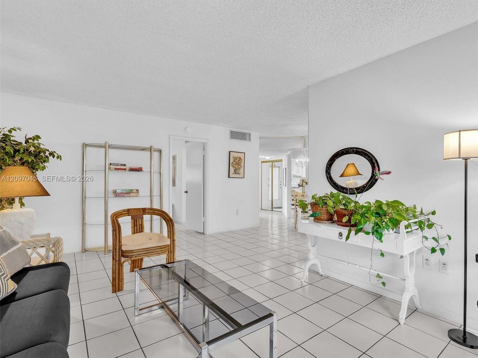 Open-concept interior featuring uniform white tile flooring throughout and neutral walls