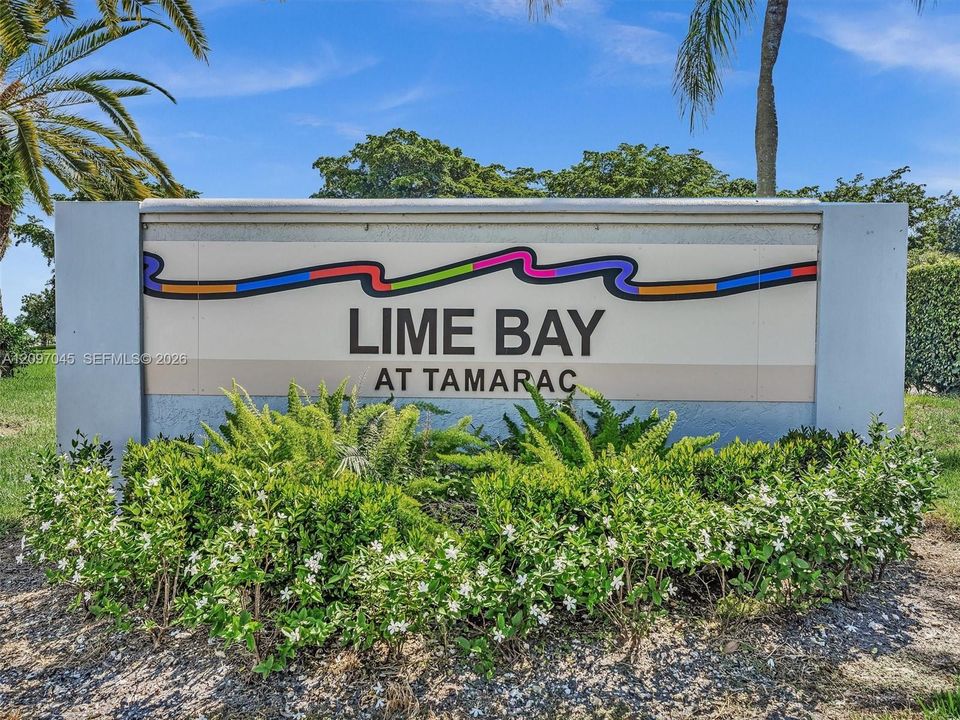Community entrance monument sign featuring structural masonry pillars and native landscaping with fern and shrubbery