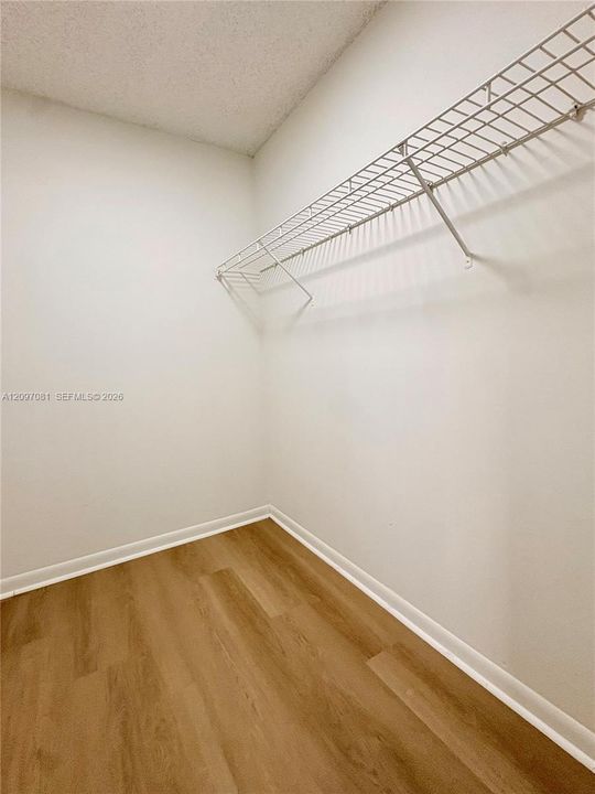 Storage area featuring wood-finish flooring and white wire shelving